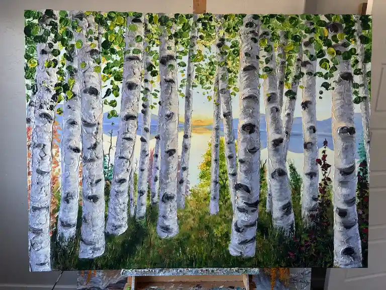 A thickly textured oil painting of a birch forest with white trunks and green leaves, displayed on an easel. The background…