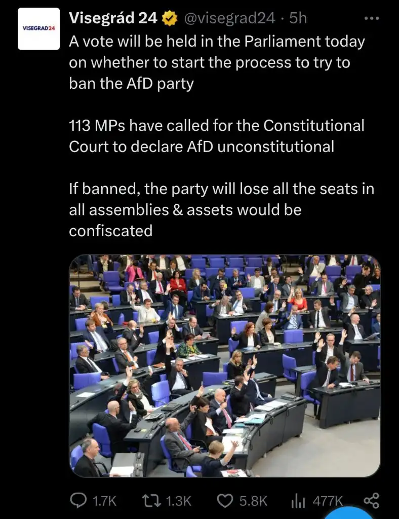 A screenshot of a tweet from Visegrád 24 shows a photo of a parliamentary chamber where many members are raising their…