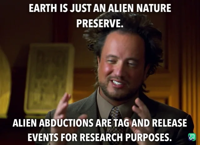 A man with messy dark hair, wearing a suit and tie, smiles while gesturing with both hands. The overlaid text reads: 'EARTH…