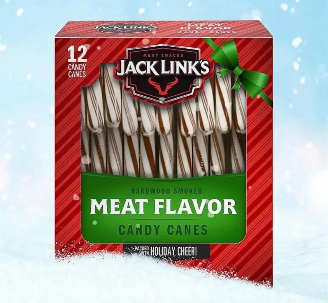 A red and green holiday-themed box of Jack Link's 'Meat Flavor Candy Canes' sits in snow, featuring candy canes with brown…