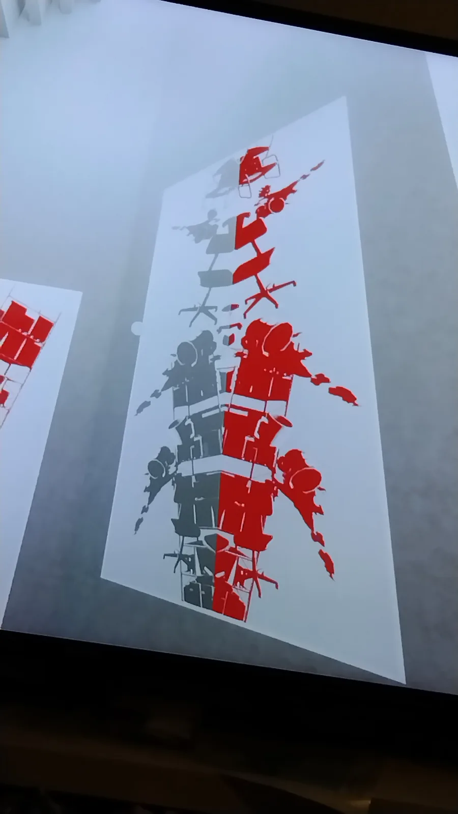 A projection shows a stylized, abstract artwork composed of red and gray silhouettes of office chairs stacked vertically to…