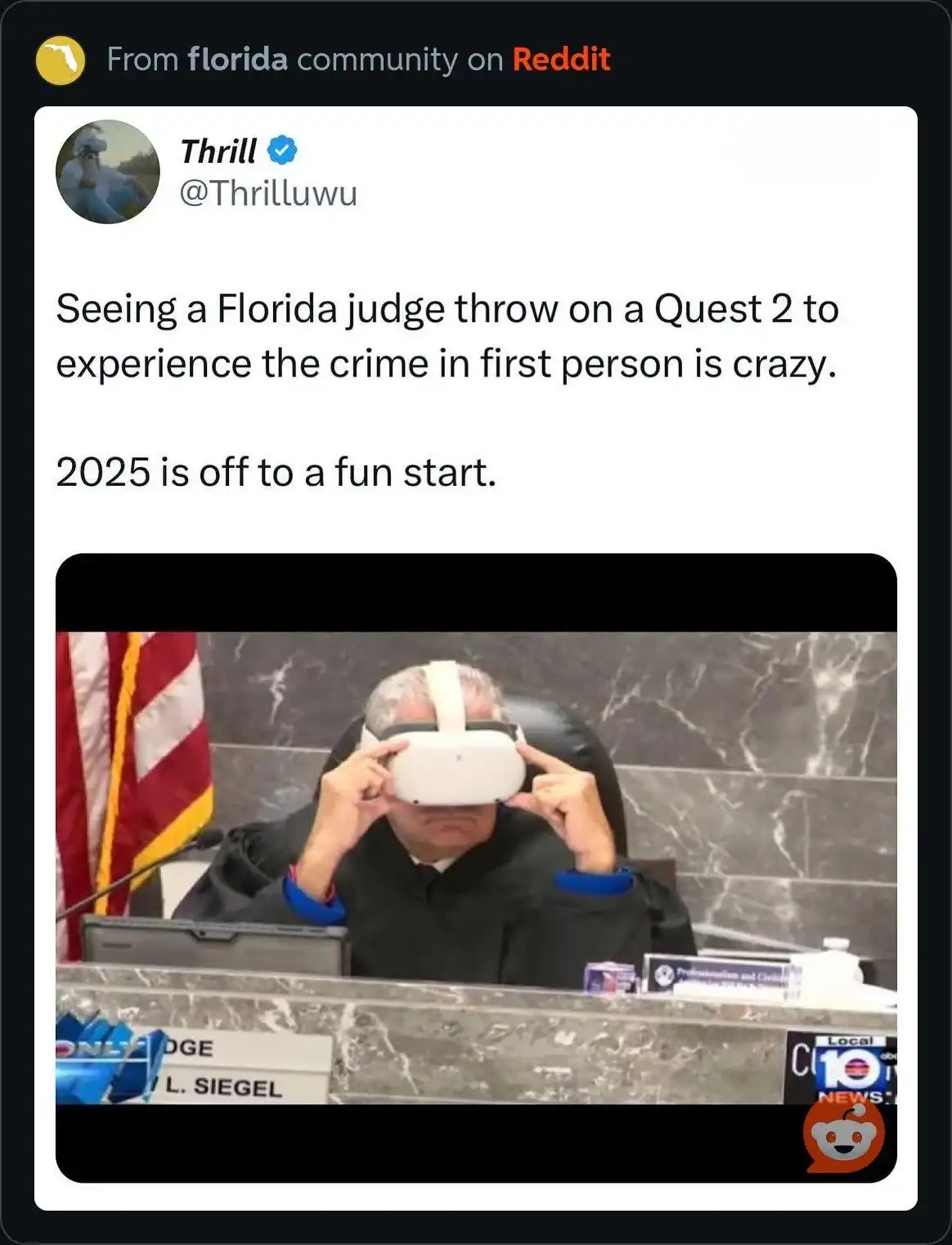 A man in a black judicial robe sits in a courtroom chair, adjusting a white VR headset over his eyes. An American flag is…